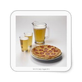 Pitcher and two pints of beer beside pepperoni stickers
