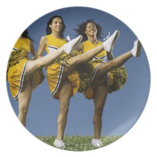 Female cheerleaders doing high kicks plates