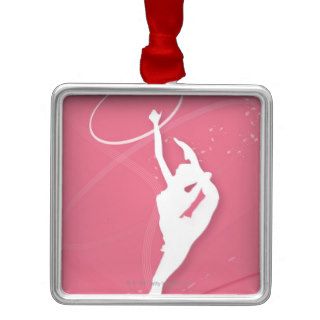 Silhouette of a female gymnast performing with a christmas tree ornament