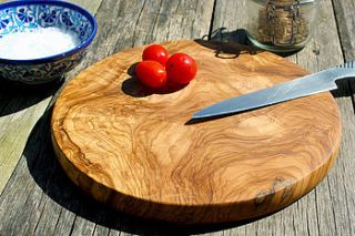 round olive wood cheese or chopping board by the rustic dish
